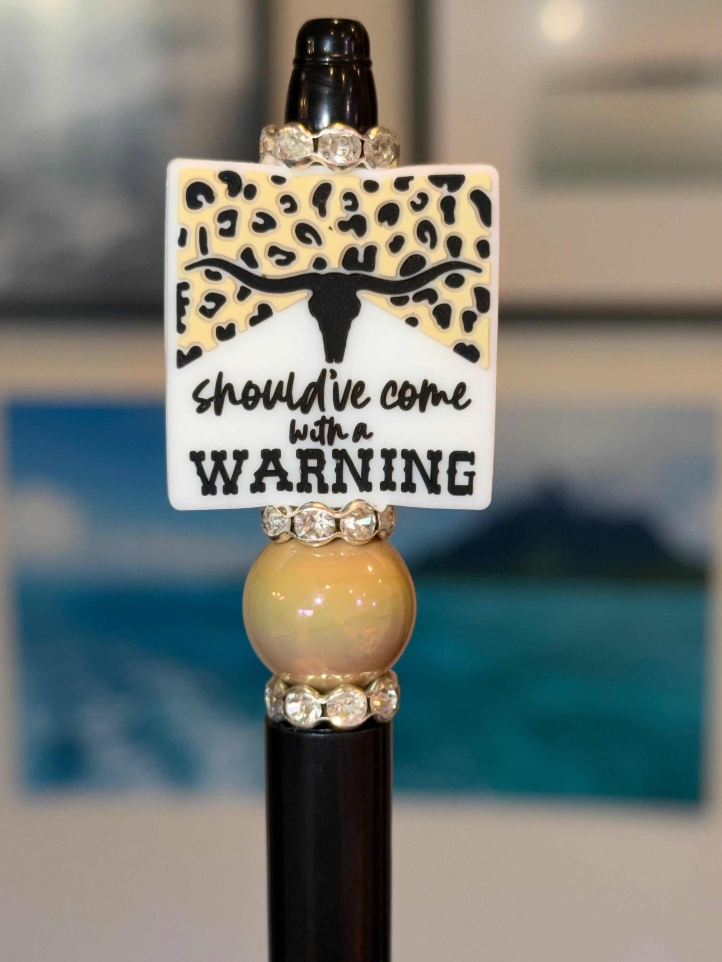 Handmade beaded pen with "Should’ve Come With a Warning" longhorn leopard print charm and rhinestone accents on black barrel