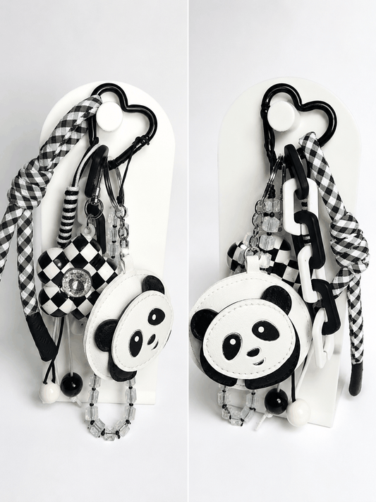 Black-and-white panda bag charm with checkered flower charm, crystal beads, heart carabiner, and gingham wristlet accent.