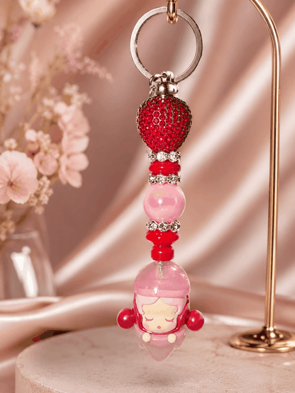Pink and red authentic Skullpanda Soda Pop bean bag charm keychain featuring decorative beads, rhinestone spacers, and a sparkling red crystal bead hanging from a silver keyring.