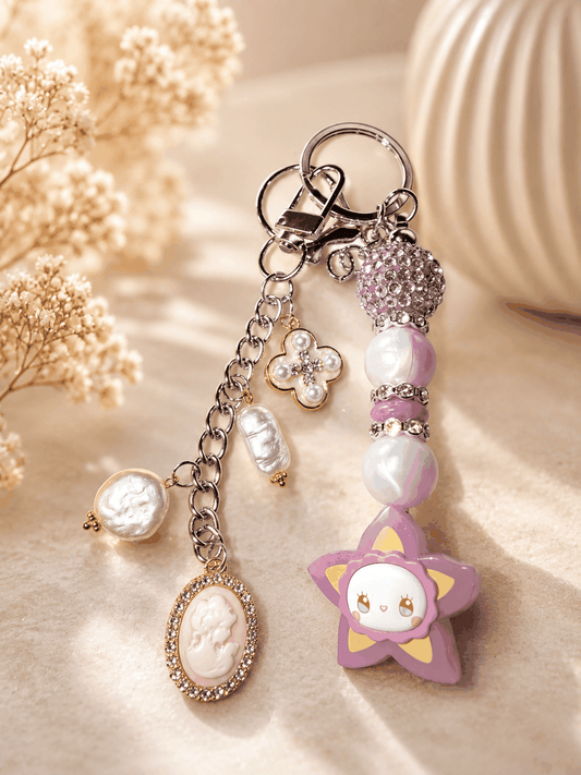 Authentic Emma Bean handmade beaded bag charm keychain featuring lavender pearl beads, a purple rhinestone bead, genuine freshwater pearl dangles, a cameo charm, floral charm, and silver keyring with lobster clasp.