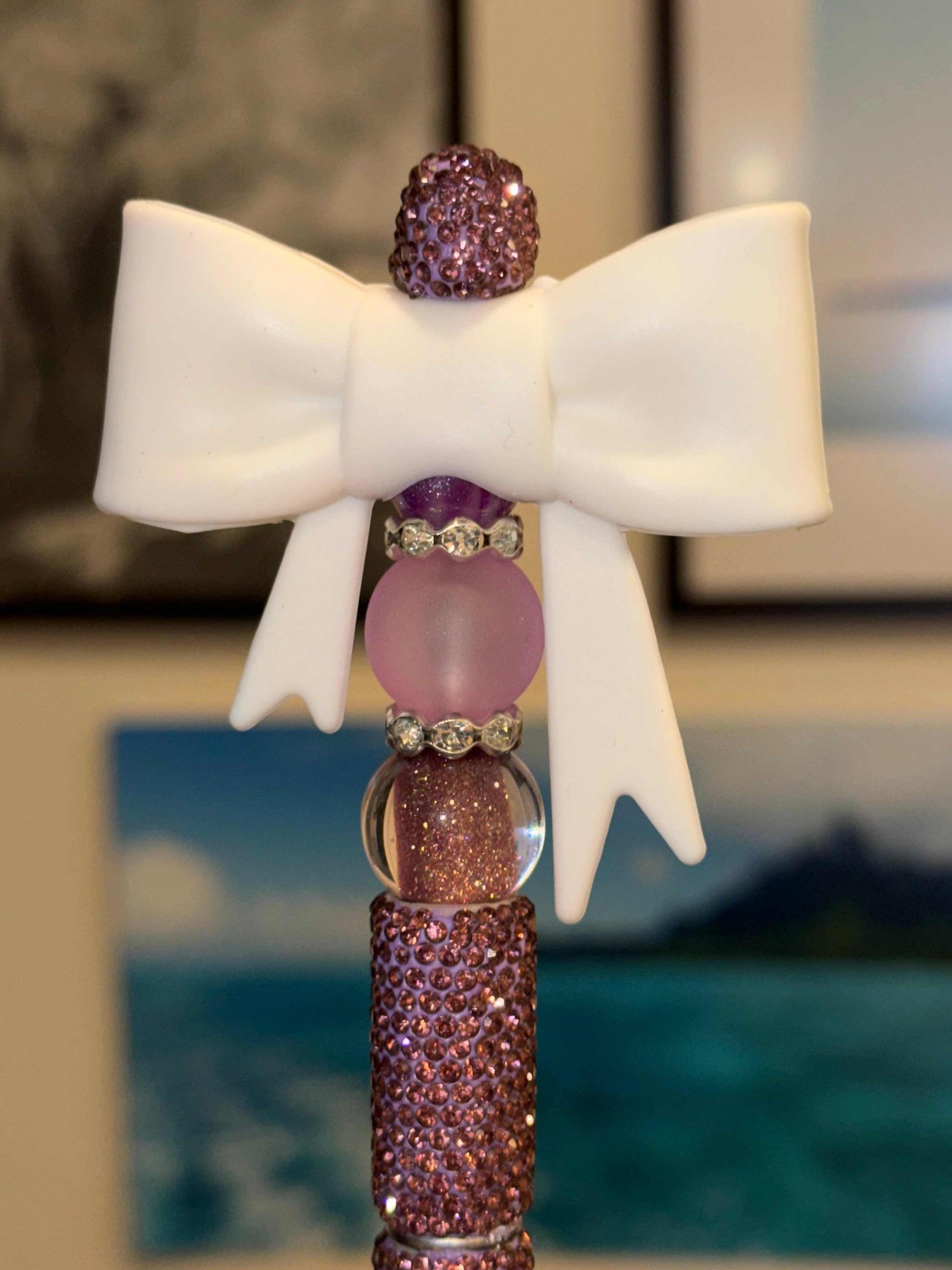 Purple rhinestone beaded pen with white bow and purple crystal accents on a sparkly purple barrel