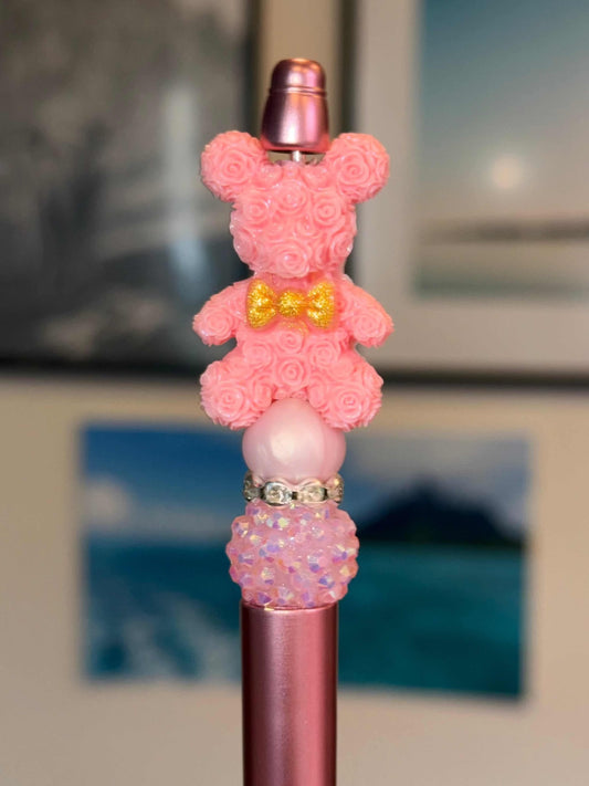 Pink Floral Bear figurine sitting on a pink pen with floral design and rhinestone details