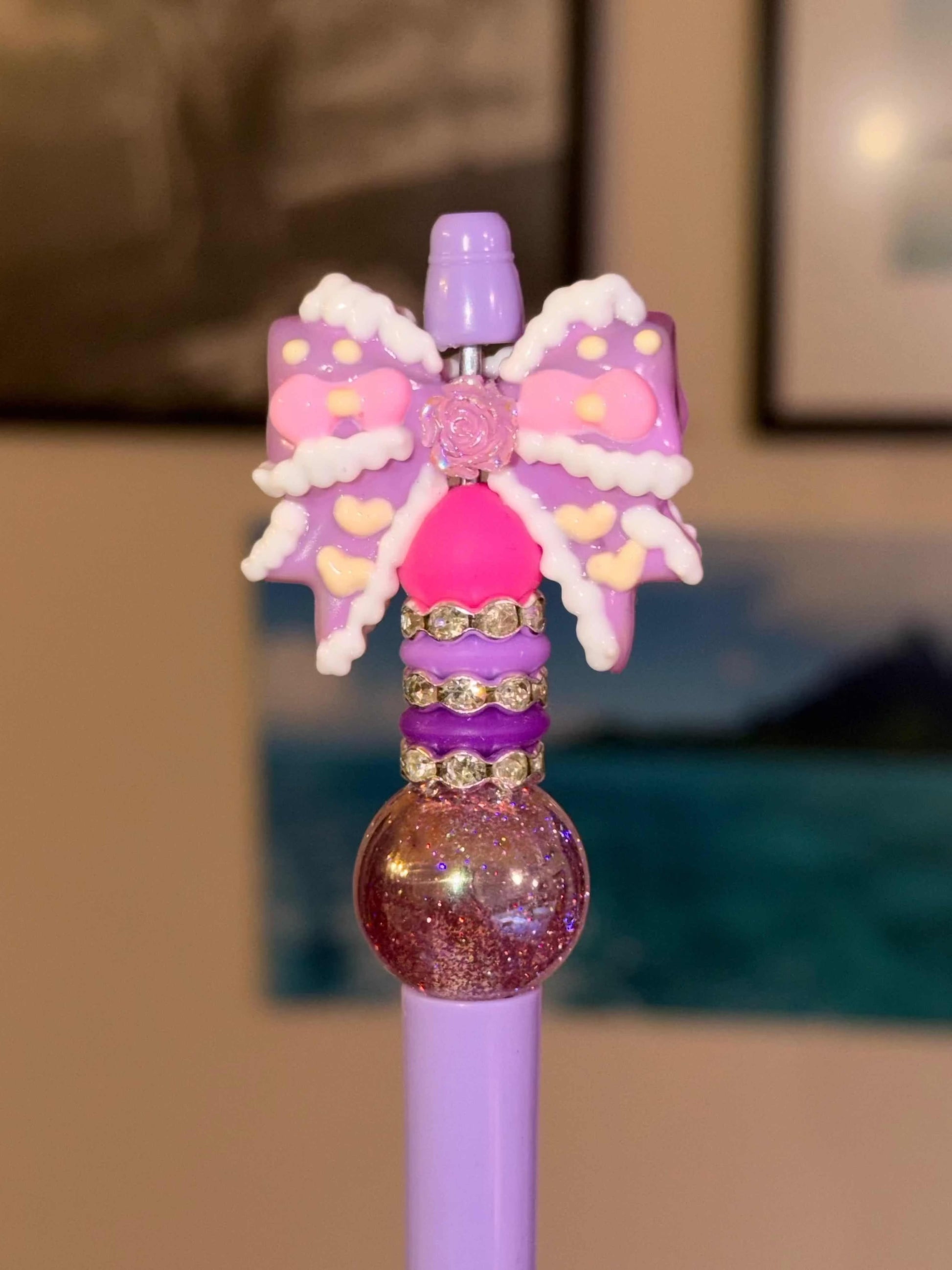 Purple and pink bow on a purple refillable pen with silicone beads and rhinestones