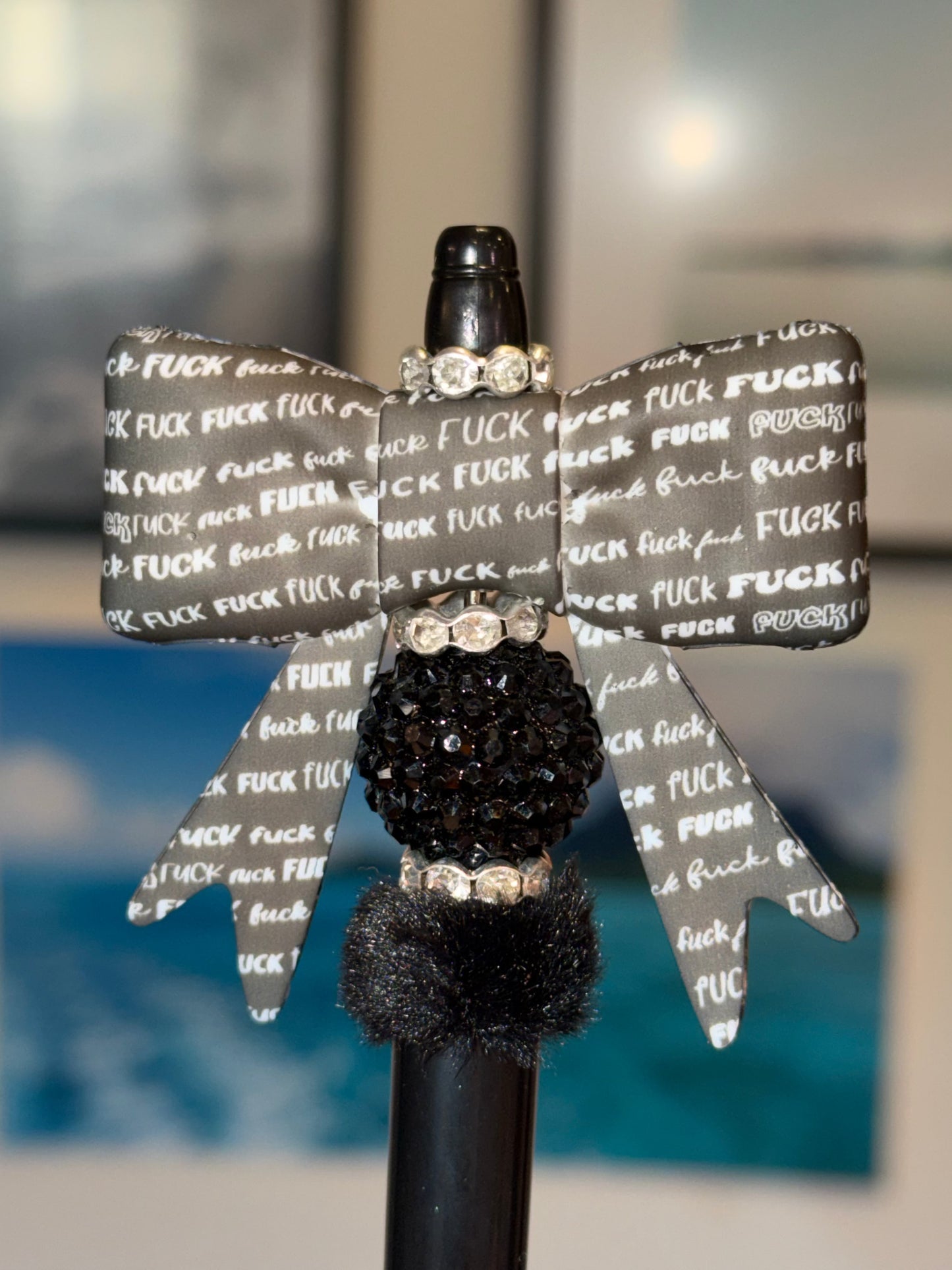 Handmade F*** Bow Beaded Pen with gray profanity print bow, black pave rhinestone bead, and black pom pom on black pen barrel