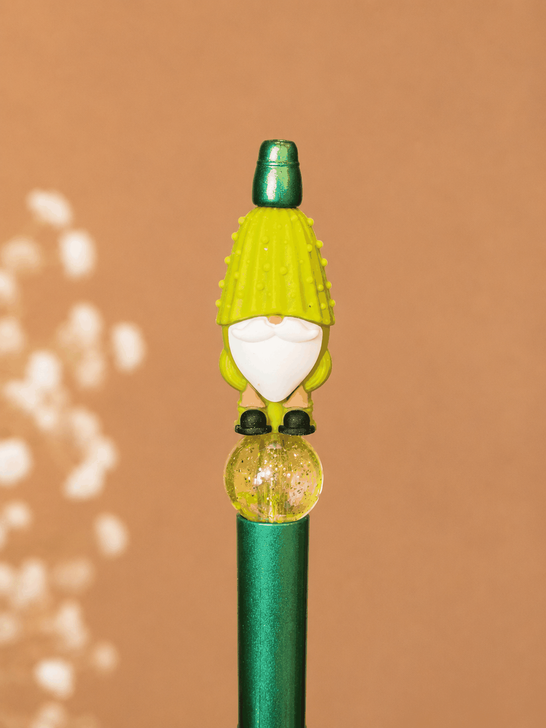 Handmade Lucky Gnome beaded pen featuring a green garden gnome topper, glitter-filled gold accent bead, and emerald green pen barrel photographed on a neutral studio background.