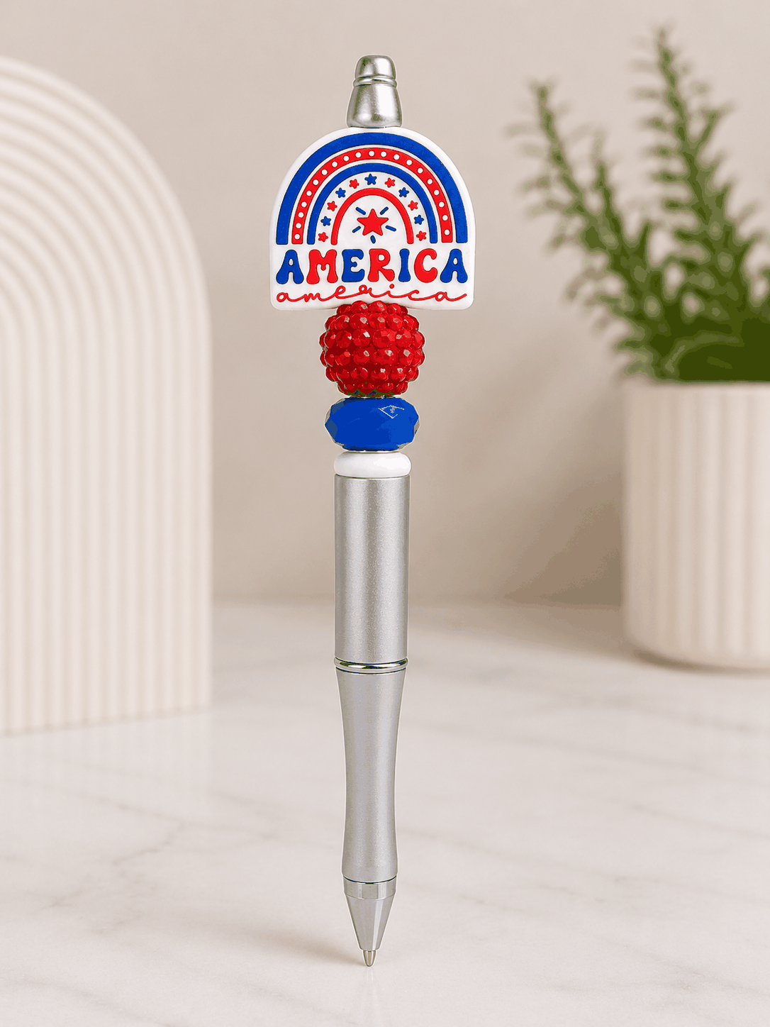 Silver beaded pen featuring a patriotic America rainbow focal bead with red and blue decorative beads in a red, white, and blue color scheme