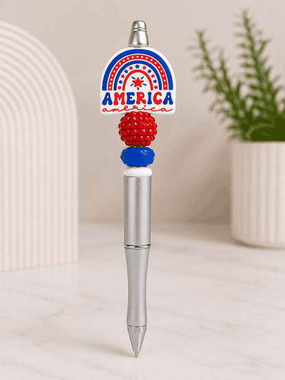 Silver beaded pen featuring a patriotic America rainbow focal bead with red and blue decorative beads in a red, white, and blue color scheme