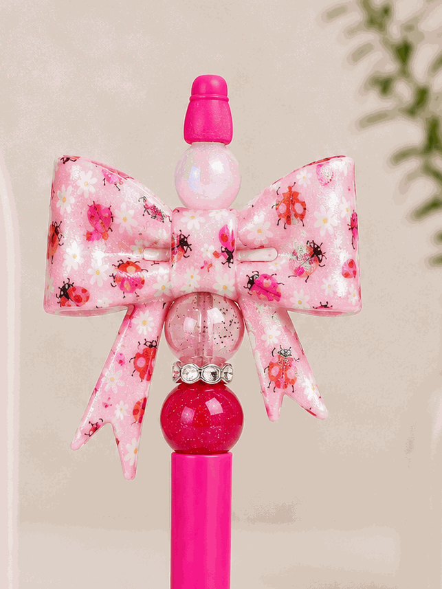 Handmade Ladybug Garden Bow pen with pink bow, ladybugs, daisies, glitter beads, and rhinestones