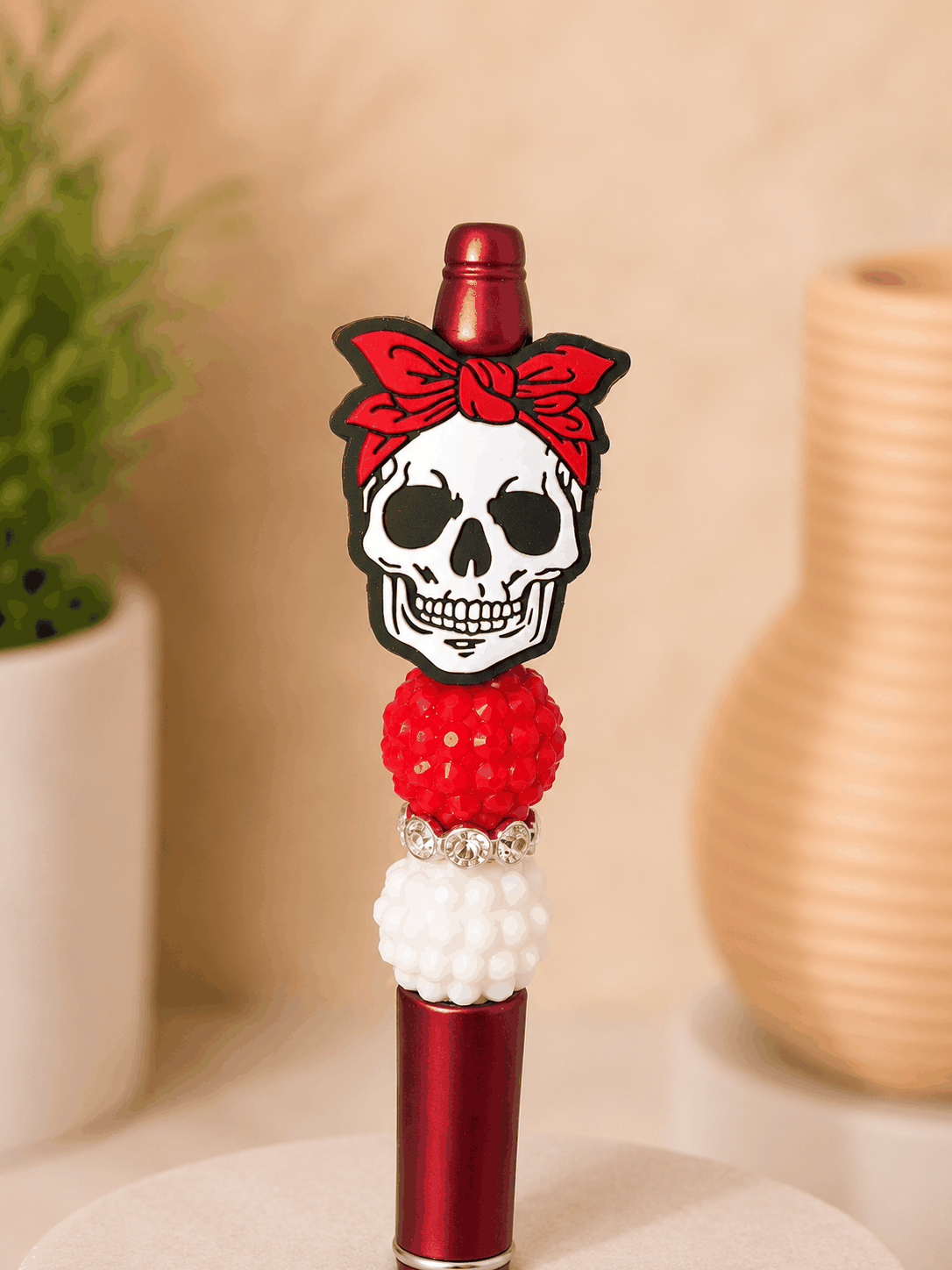 Handmade skull beaded pen with red bandana, rhinestone accents, and textured red and white beads
