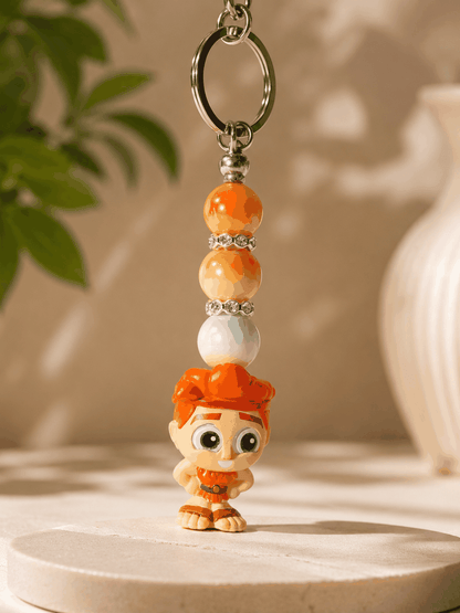 Authentic Disney Hercules Doorable keychain featuring a Hercules character charm with orange and gold beads, iridescent accents, rhinestone spacers, and a silver keyring displayed on a professional neutral background.