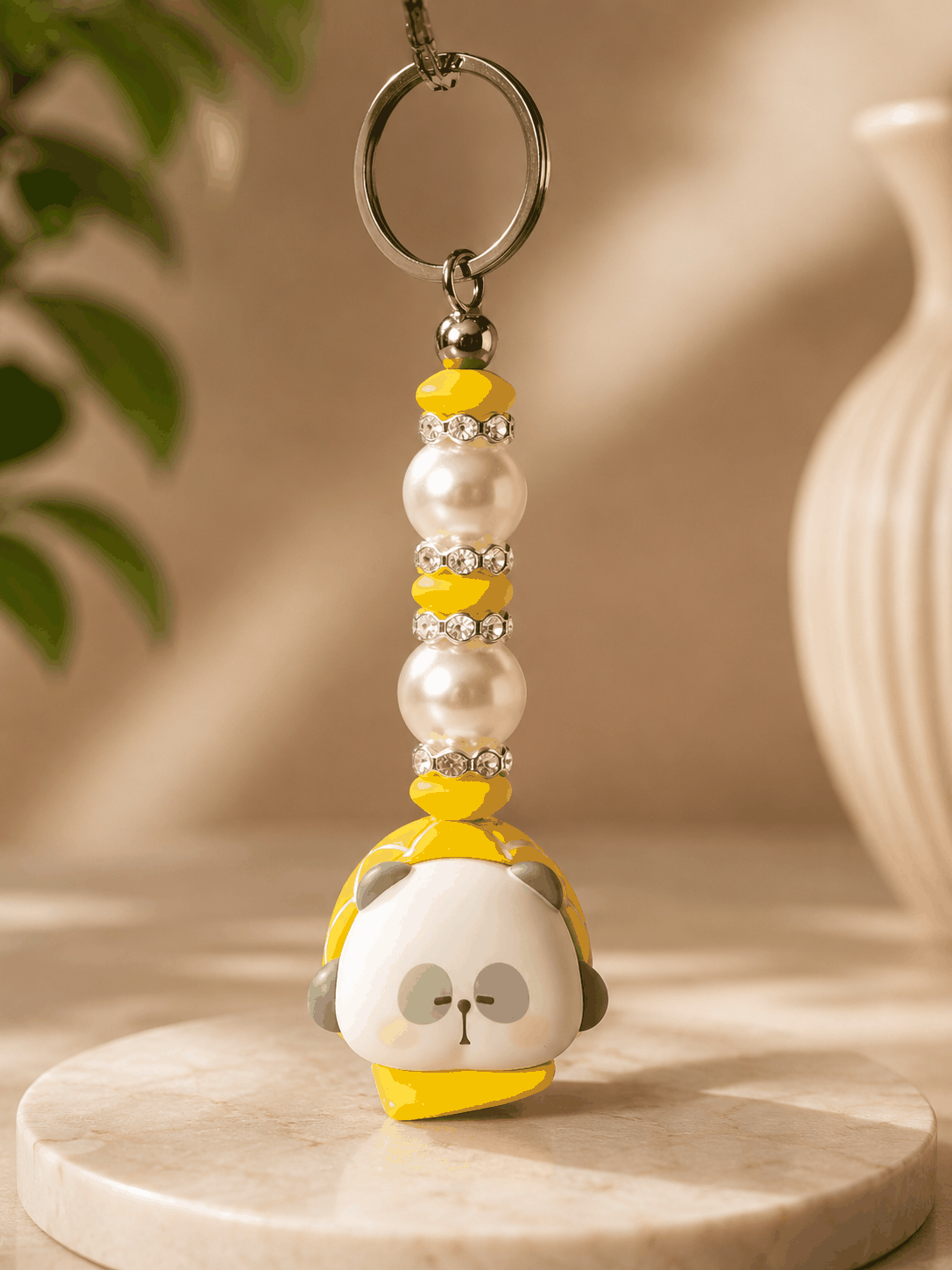 Authentic Mr. Pa bean bag charm keychain featuring a yellow character charm, pearl beads, yellow accent beads, rhinestone spacers, and a silver keyring displayed on a neutral professional product photography background.