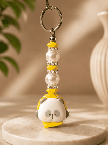Authentic Mr. Pa bean bag charm keychain featuring a yellow character charm, pearl beads, yellow accent beads, rhinestone spacers, and a silver keyring displayed on a neutral professional product photography background.