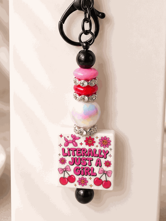 Literally Just a Girl beaded keychain charm with pink florals, cherries, black beads, pink accents, pearl bead, and rhinestones handcrafted accessory