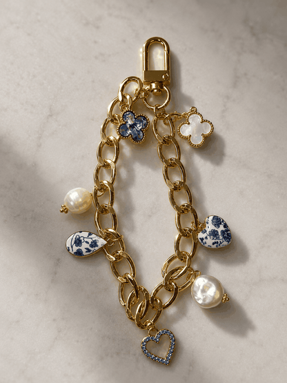 Elegant gold bag charm chain with pearls and blue porcelain-inspired charms