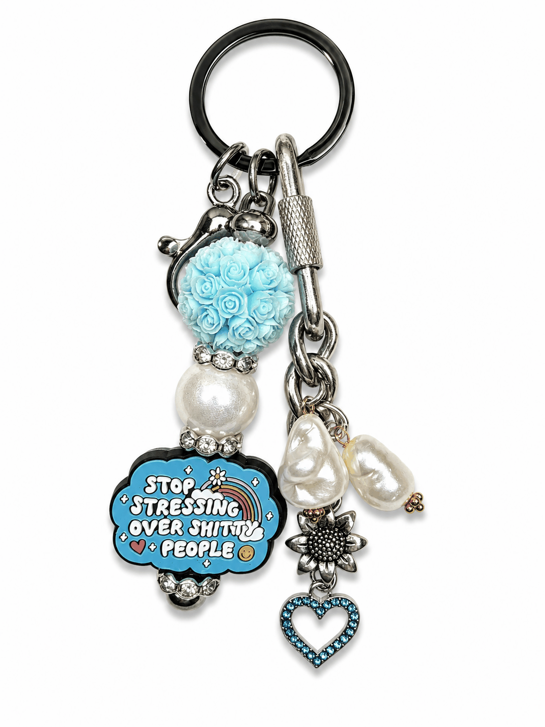 Handmade funny motivational bag charm featuring a blue floral bead, freshwater pearls, sunflower charm, blue crystal heart pendant, and silver hardware on a white background. the funny charm says stop stressing over shitty people. 