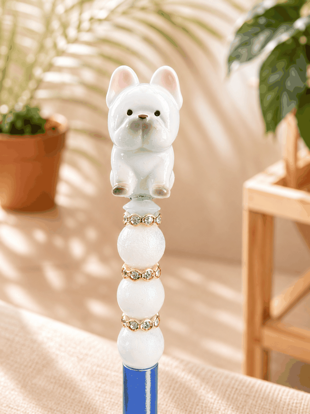 Authentic Meichai French Bulldog Bean handmade beaded pen featuring a white Frenchie dog topper, pearl shimmer beads, gold rhinestone spacers, and a metallic blue ballpoint pen barrel.