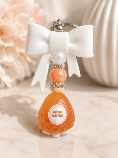 Handmade authentic Emma Strawberry bean bag charm keychain with white bow, pastel beads, and rhinestone accents displayed on a neutral background.