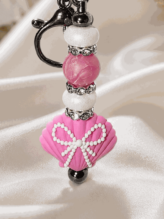 Handmade pink seashell beaded bag charm with pearl beads and rhinestone spacers on black hardware keychain