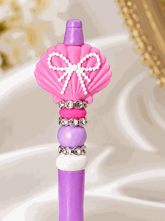 Handmade pink seashell beaded pen with purple glitter body and rhinestone accents